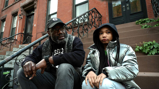 Ralph James sits beside his daughter Bug on a brownstone stoop in Bed-Stuy, Brooklyn.