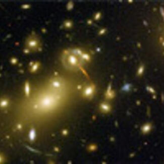 A NASA photo of blurry white spots against the black of space: a Hubble Telescope image of galaxy cluster Abell 2218.