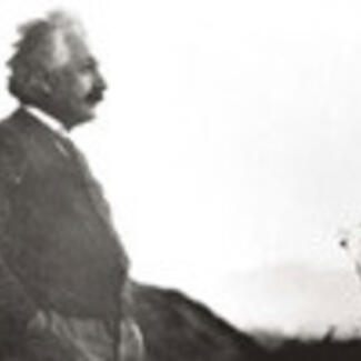 A man, Albert Einstein, in profile, standing outdoors.