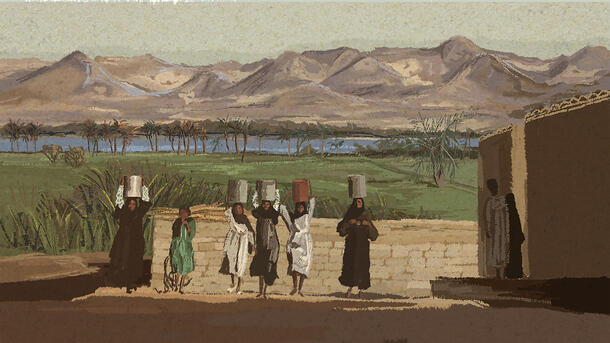 Six people, five of them carrying cylindrical objects on their heads, walk in a row on a sandy street, with the Nile River visible in the background.