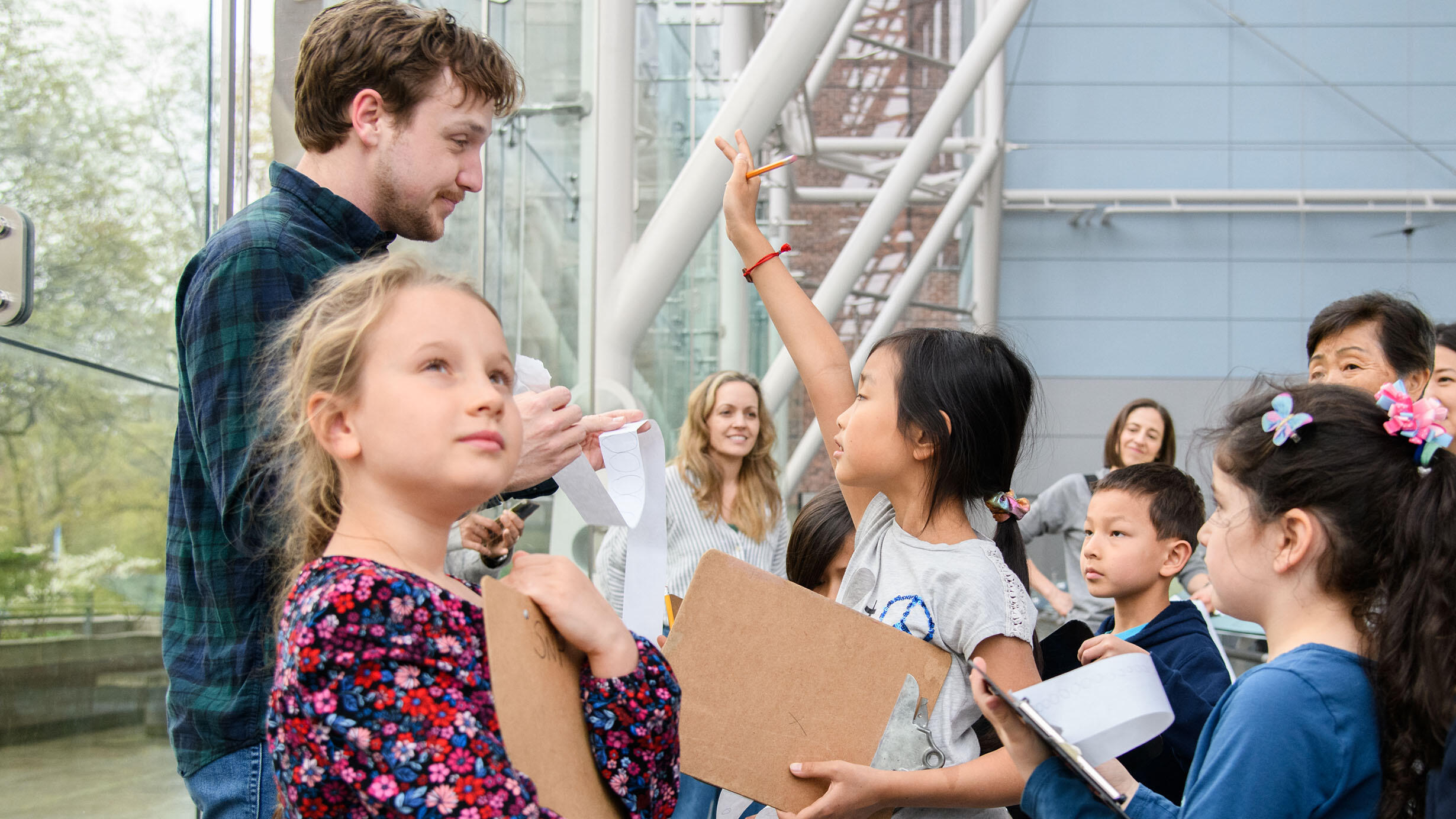 A small group of children and adults gather around a Museum educator inside the Rose Center for Earth and Space.