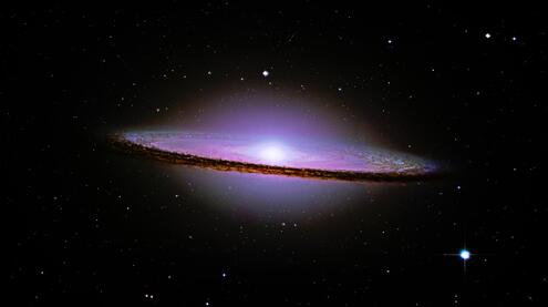 Sideview of a galaxy with a large elliptical halo. 